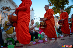老挝佛教僧侣在遍布未爆炸弹的地区祈祷的照片